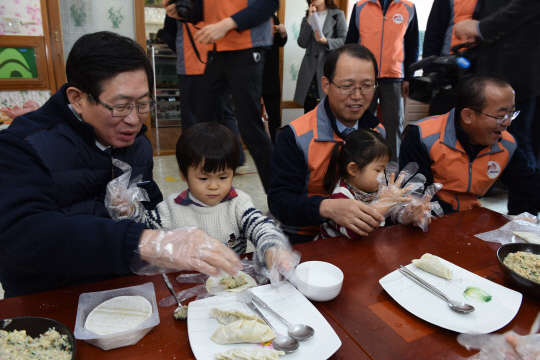 조환익 한국전력 사장(왼쪽) 등이 사회복지시설을 방문해 아이들과 만두빚기 봉사활동을 벌이고 있다. <한국전력 제공>